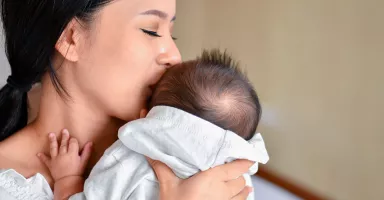 Síndrome de Menkes Madre abrazando a su bebé con síndrome de Menkes