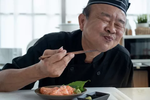 Cocinero japonés saboreando su plato con cara de satisfacción