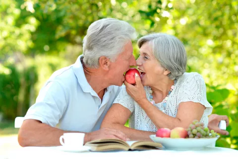 Pareja mayor comiendo fruta