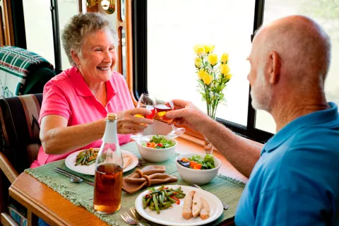 Una pareja mayor brinda antes de comenzar a comer