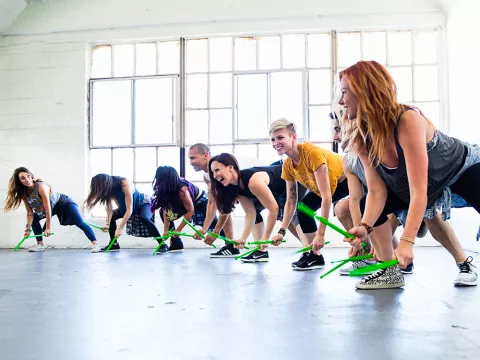 Grupo agita las batutas haciendo pound fitness