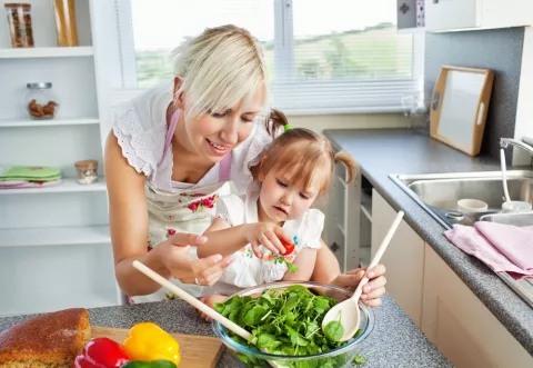 Madre jugando con su hija en la cocina