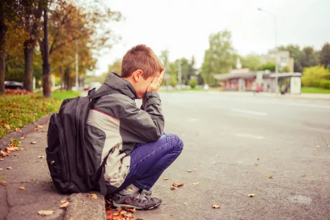 Niño con mochila triste