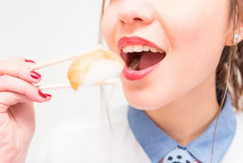 Mujer comiendo pescado crudo