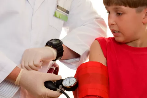 Médico tomando la tensión a niño con escarlatina