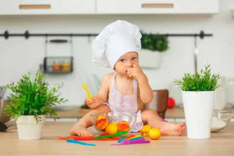 Bebé comiendo fruta entera de temporada