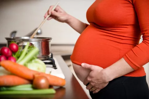 Embaraza cocinando verduras