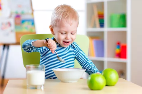 Niño pequeño comiendo solo