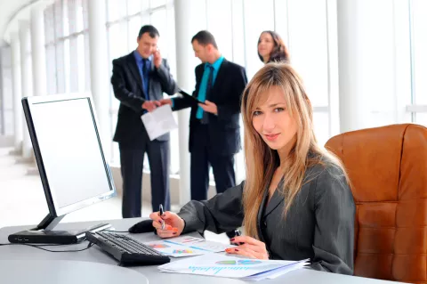 Una mujer organiza sus tareas en su puesto de trabajo