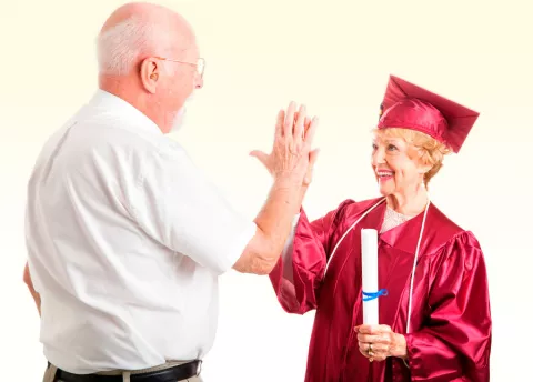 Un hombre mayor felicita a su mujer recién graduada