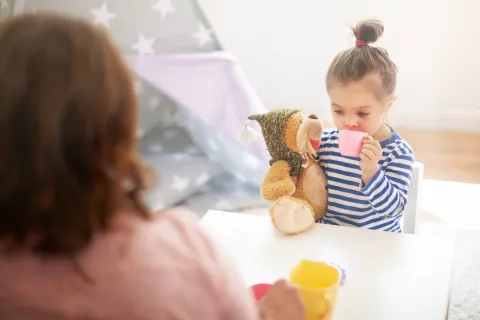 Madre viendo a su hija jugar con su amigo imaginario