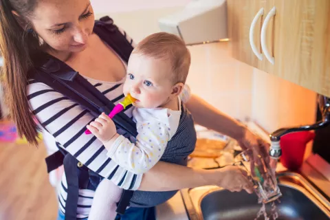 Madre limpiando con portabebés