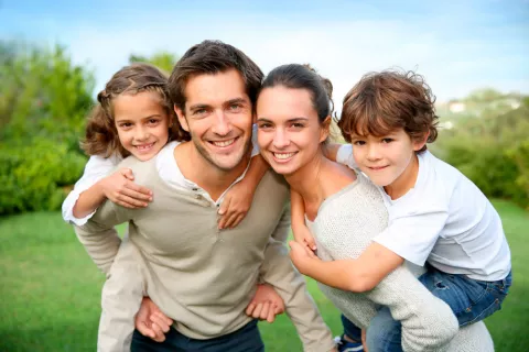 Una pareja y sus hijos sonrientes en el campo