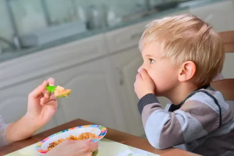 Madre alimentando a su hijo con cáncer con disgeusia