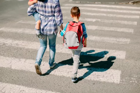 Madre enseña a cruzar la carretera a sus hijos