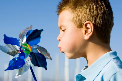 Niño soplando un molinillo