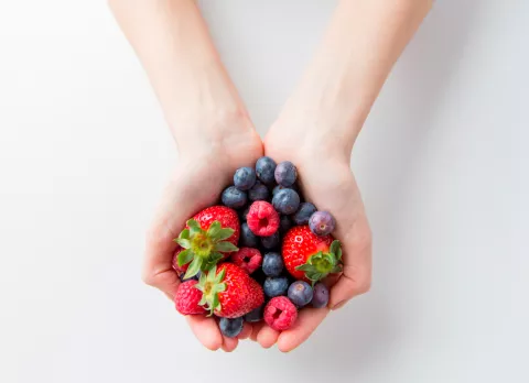 Un puñado de frutos rojos, como arándanos y frambuesas