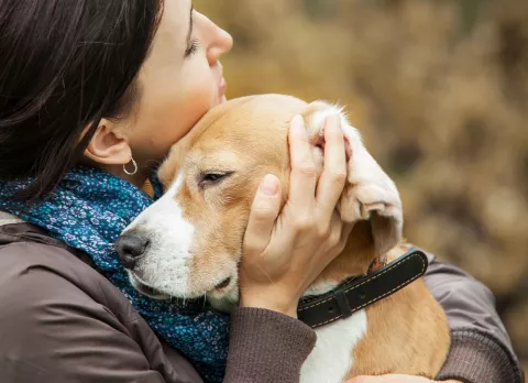 Una mujer abraza a su perro