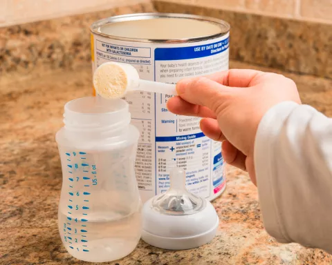 Preparación de un biberón añadiendo al agua leche de crecimiento en polvo