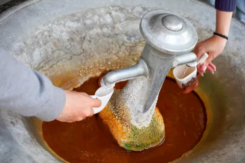 Dos personas llenan sus jarritas con agua de una fuente en Karlovy Vary