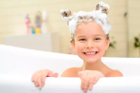 Niña lavándose el pelo con un pediculicida