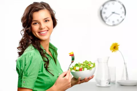 Mujer joven comiendo una ensalada