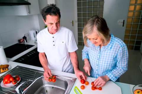 Pareja de jubilados preparando recetas veraniegas