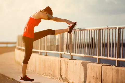 Una mujer calienta antes de comenzar a practicar power walking