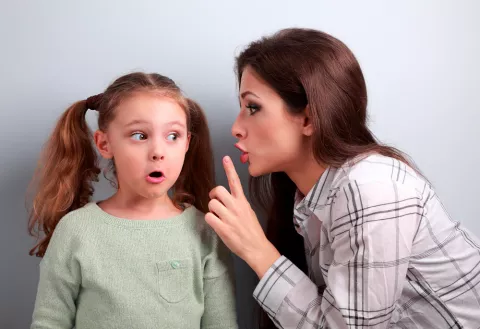 Madre cuchicheando a su hija