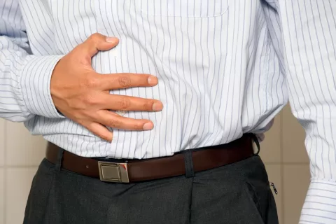 Hombre se toca el abdomen dolorido