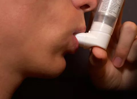 Paciente medicándose con un inhalador