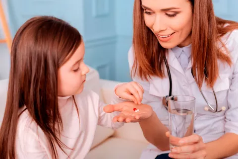 Niña tomando pastilla para tratar la TDAH