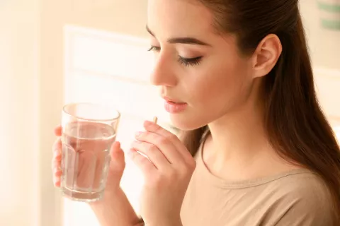 Mujer tomando Tinidazol