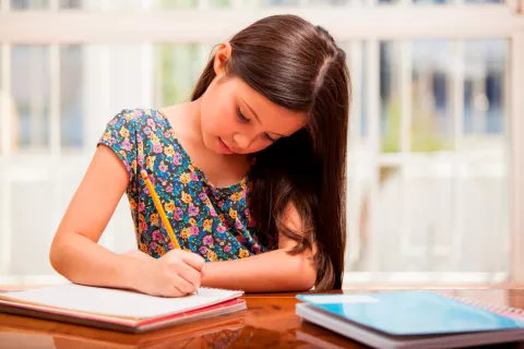 Niña estudiando en casa