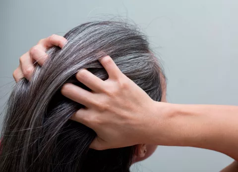 Mujer mesándose las canas