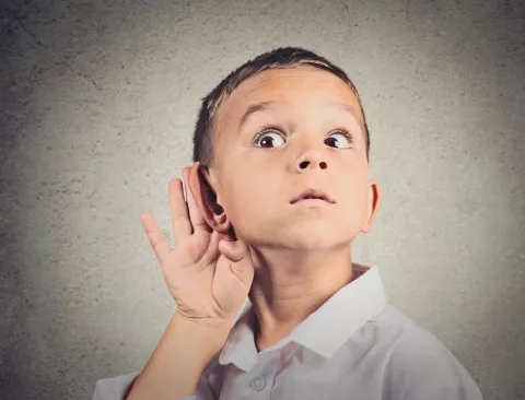 Un niño se toca la oreja demostrando atención