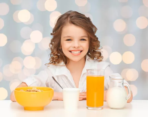 Niña tomando un ejemplo de desayuno saludable y sencillo