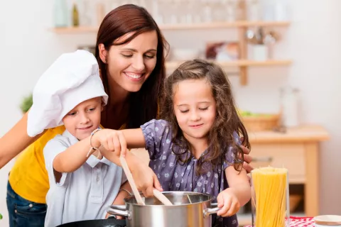 Una madre cocinando con sus hijos