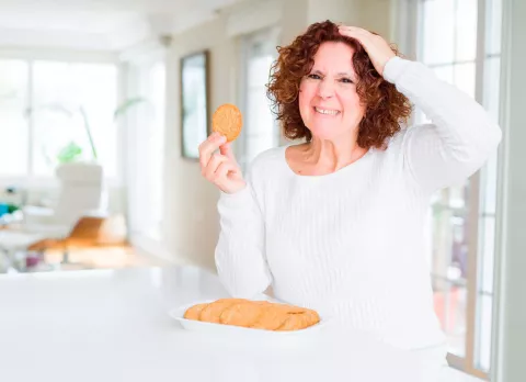 Una mujer preparando la comida con gesto aburrido