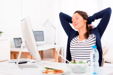 Mujer comiendo mientras trabaja