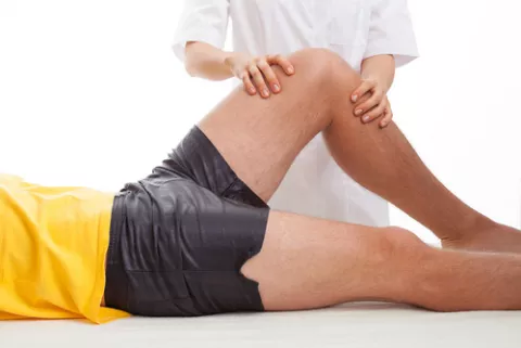 Terapeuta tratando la rodilla de un paciente