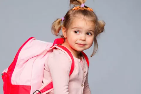 Niña con la cartera preparada para ir al colegio