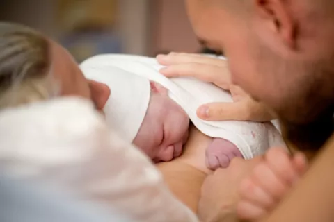 Mujer recién parida con su bebé y marido