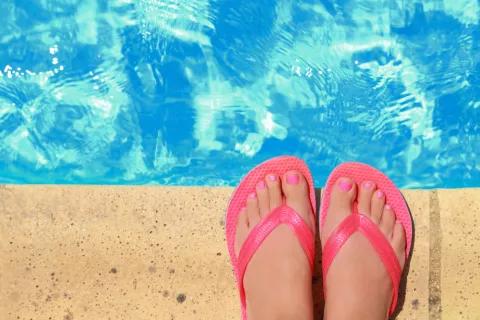 Usar chanclas en la piscina para prevenir el pie de atleta