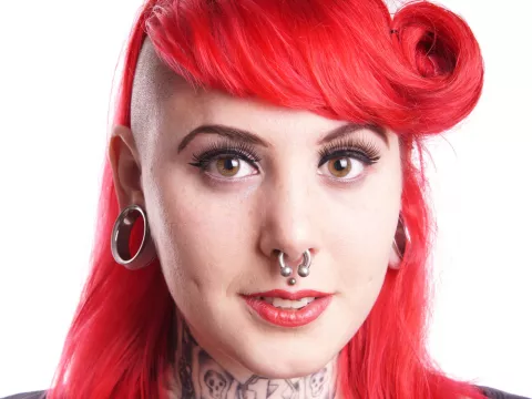 Chica con diversos piercing en la cara y orejas