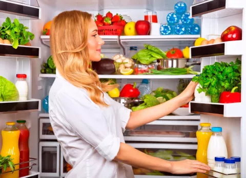 Mujer colocando los alimentos en la nevera