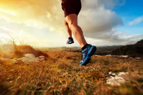 Piernas de un hombre corriendo por el campo