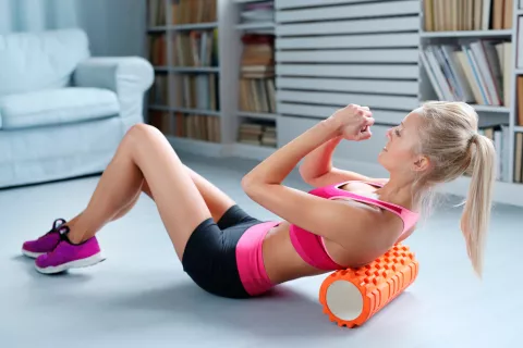 Chica entrenándose con un foam roller