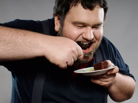 Hombre con food craving devora un postre