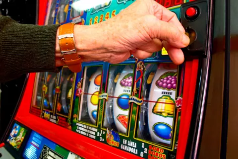 Hombre ludópata jugando en una máquina de casino